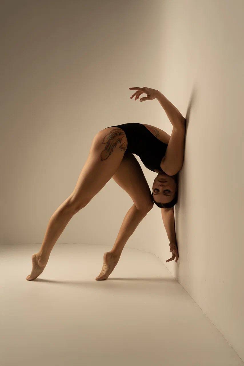 Portrait of Evgenia Davydova in a studio pose beside a wall