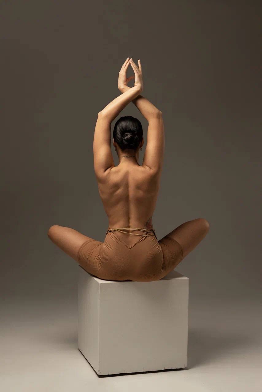 Evgenia Davydova seated with her back turned in warm studio light
